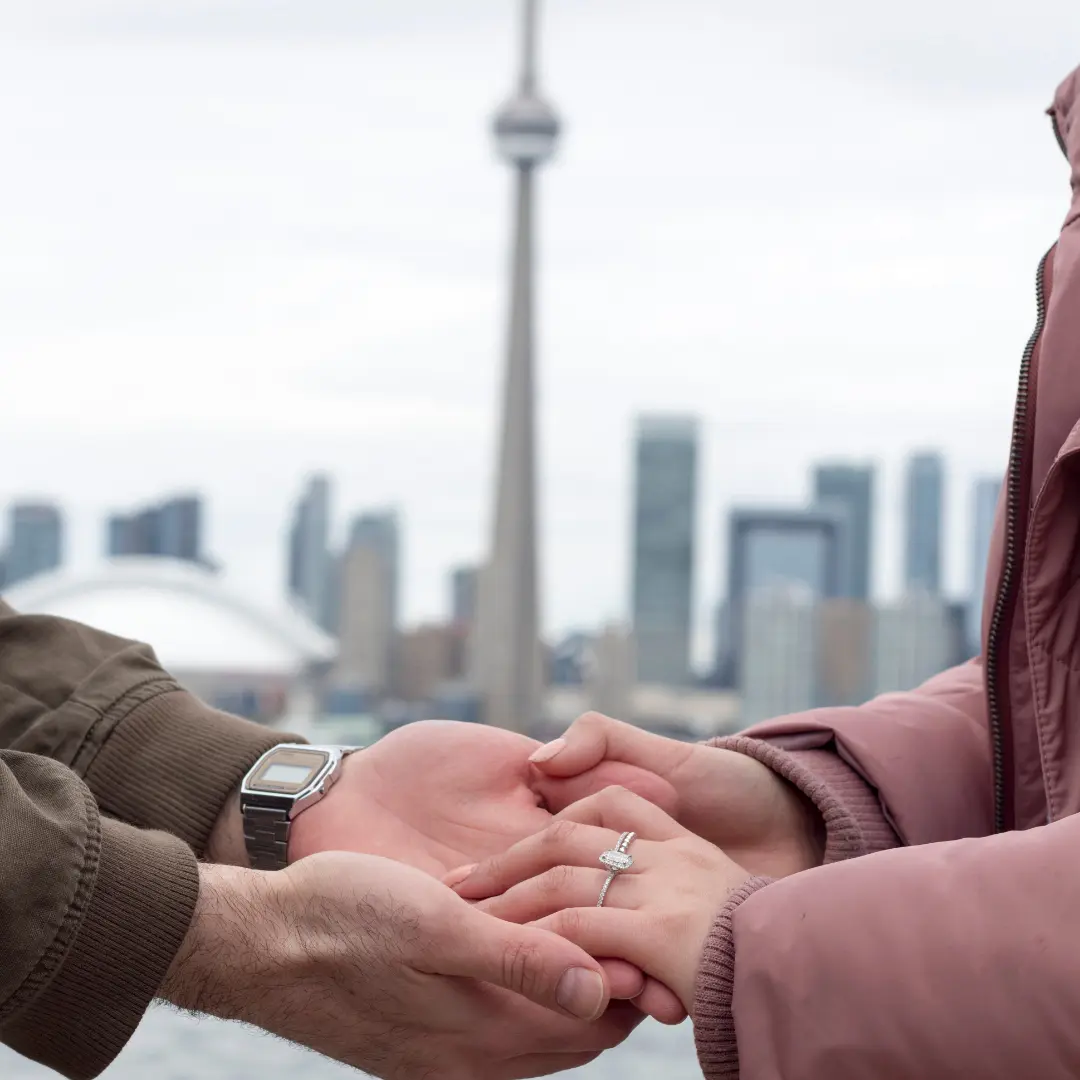 Couple holding hands in front of the Toronto skyline with the CN Tower in the background