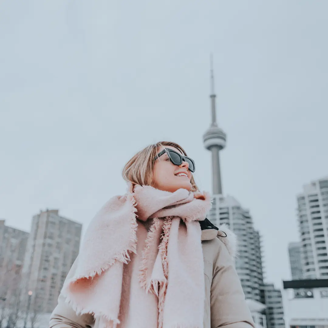 Fashionable woman in a hijab standing in downtown Toronto with the CN Tower in the background