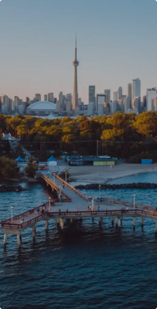 Toronto skyline view from Toronto Islands with greenery and wooden docks in the foreground